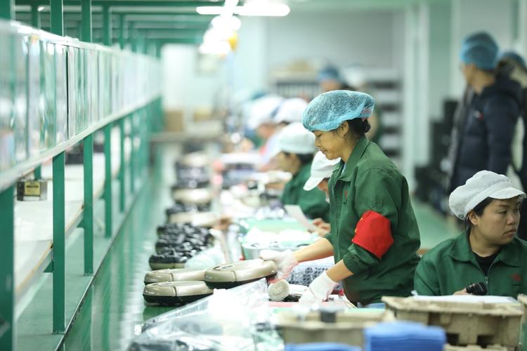 深圳家卫士工厂,女工覃益秋正在检查产品外观是否有缺陷.